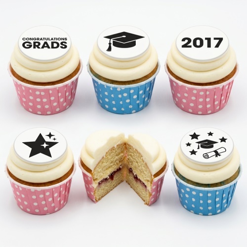 Graduation cupcakes with white frosting, pink and blue cases, and black graduation-themed toppers.