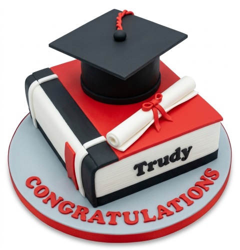 Graduation cake shaped like a book with a black mortarboard, diploma scroll, and red 'Congratulations' message.