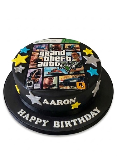 Round black Grand Theft Auto V themed birthday cake with game cover print and star decorations.