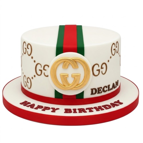 White round cake with red and green Gucci stripe, gold interlocking G logo, and repeating GG pattern.