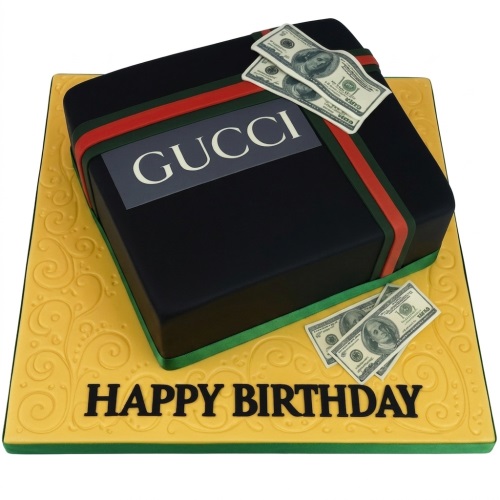 Black square gift box cake with red and green stripes, a 'GUCCI' logo, and edible dollar bills on top and on a gold patterned cake board.