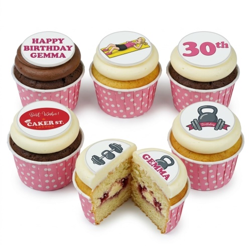 Assortment of gym and fitness themed birthday cupcakes with edible toppers, including dumbbells, kettlebell, and a yoga pose.
