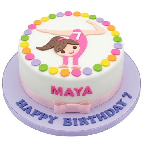 Round white cake with a fondant gymnast girl, multi-coloured polka dots, and a pink ribbon.