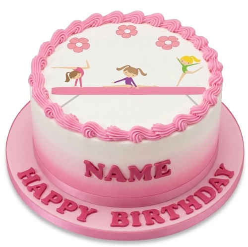 Round white and pink ombre cake with cartoon gymnasts on a balance beam, pink piped icing, and custom name.
