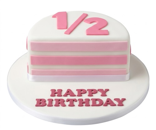 White half birthday cake with pink stripes, a pink "1/2" topper, and "Happy Birthday" written on the board.