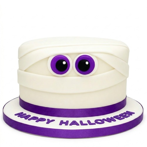 White mummy cake with purple eyes and a purple 'Happy Halloween' message on the board.