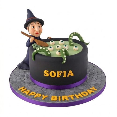 Witch themed birthday cake with a witch figure, black cauldron, green liquid, eyeballs, and tentacles.