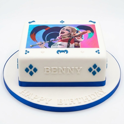 Square white fondant cake with an edible Harley Quinn image and blue diamond decorations.