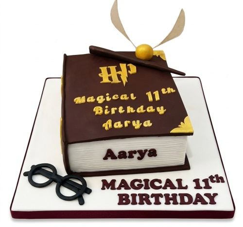 Harry Potter themed book birthday cake with golden snitch, wand, and glasses, featuring custom age and name.