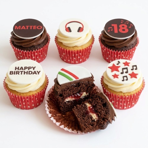 A set of music-themed birthday cupcakes with custom age and name toppers, featuring headphones, musical notes, and stars.