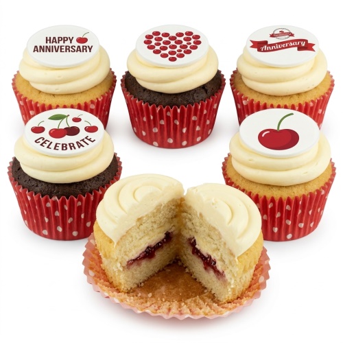 Six cupcakes with white frosting and cherry-themed edible toppers in red and white polka dot cases.