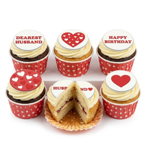 Six cupcakes with white frosting, red heart toppers, and birthday messages for a husband.