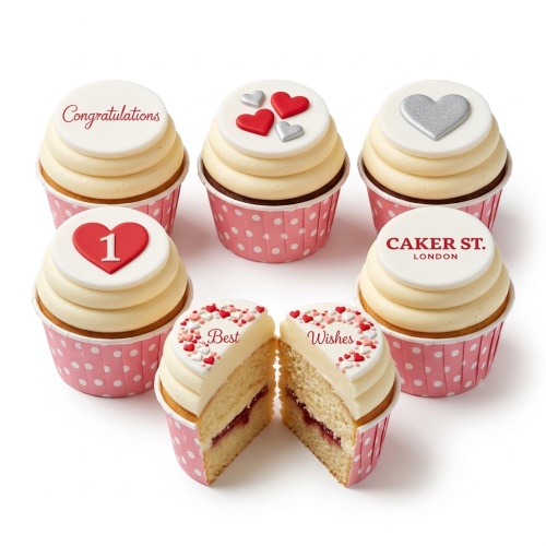Cream cupcakes with white fondant toppers, decorated with red and silver hearts, heart sprinkles, and custom messages.