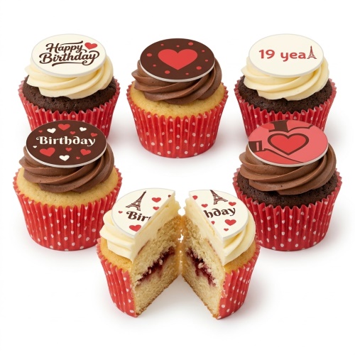 Cupcakes with red polka dot wrappers, chocolate and vanilla frosting, edible hearts, Eiffel Tower, and 'Happy Birthday' toppers.