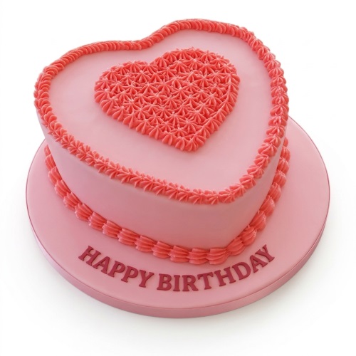 Pink heart-shaped birthday cake with piped heart decoration and 'Happy Birthday' message on the board.