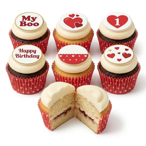 A set of cupcakes with white frosting and red heart-themed edible toppers, some with custom messages and a number 1, in red polka dot wrappers.