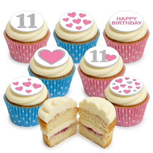 Birthday cupcakes with white frosting, pink and blue wrappers, topped with glitter numbers and pink hearts.