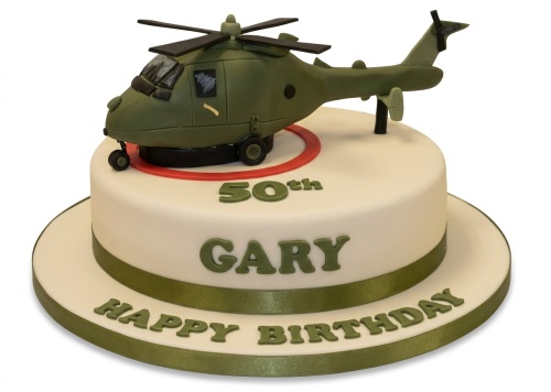White fondant cake with a green 3D helicopter topper and green ribbon.