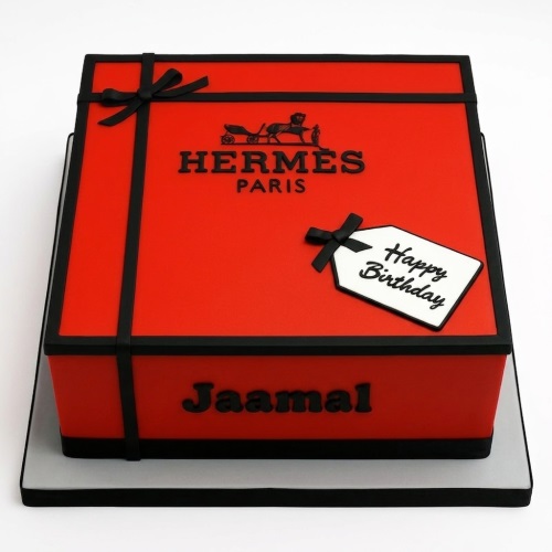 Red and black Hermes gift box birthday cake with a 'Happy Birthday' tag and custom name.