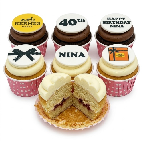 Hermes-inspired birthday cupcakes with custom age and name toppers, bow, and gift box designs on vanilla and chocolate frosting.