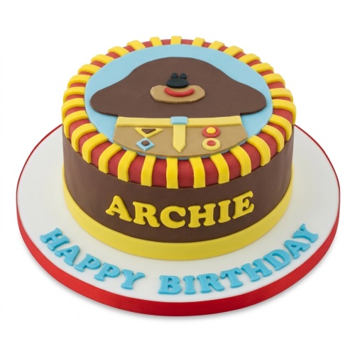 Round single-tier Hey Duggee birthday cake with brown, blue, red, and yellow fondant, featuring Duggee's head and badge, and space for a personalised name.