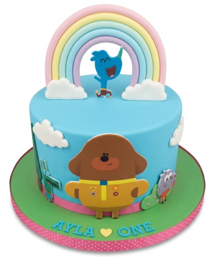 Hey Duggee birthday cake with a rainbow, clouds, and characters on a blue and green base.
