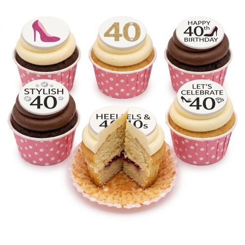 A selection of 40th birthday cupcakes with high heel and diamond toppers on pink polka dot wrappers.