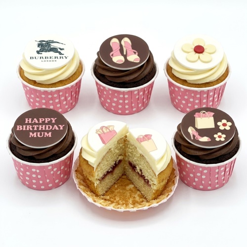 Assortment of designer-themed birthday cupcakes with high heels, shopping bags, a flower, and a custom message topper.