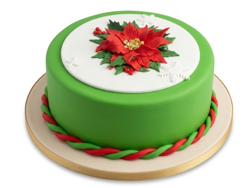 Round green Christmas cake with a red poinsettia, berries, and white snowflakes on top.