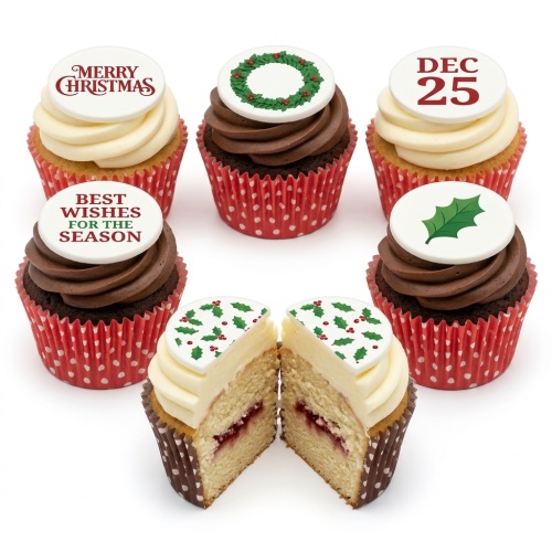 A selection of Christmas cupcakes with white and chocolate frosting, decorated with edible toppers featuring holly, a wreath, "Merry Christmas", "Best Wishes for the Season", and "DEC 25". One cupcake is cut in half showing a jam filling.