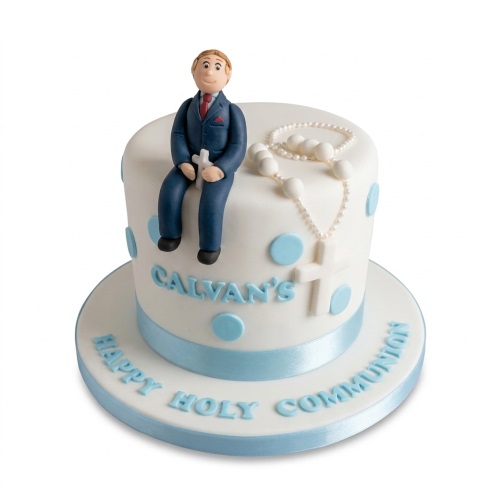 White Holy Communion cake for boys with a figurine, rosary, cross, and blue polka dots.