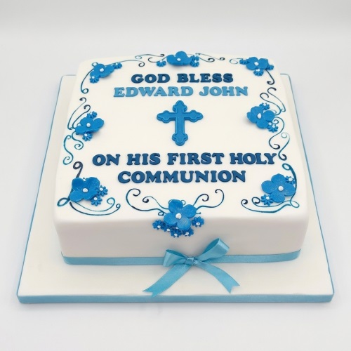 White square First Holy Communion cake with blue cross, floral details, and personalised message.