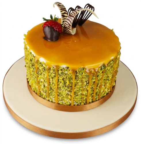 Round pistachio and caramel drip cake with chocolate-dipped strawberry and chocolate curls.