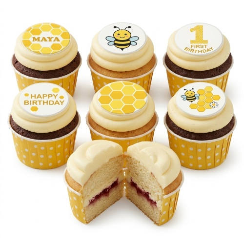 A set of bee and honeycomb themed birthday cupcakes with custom message toppers.