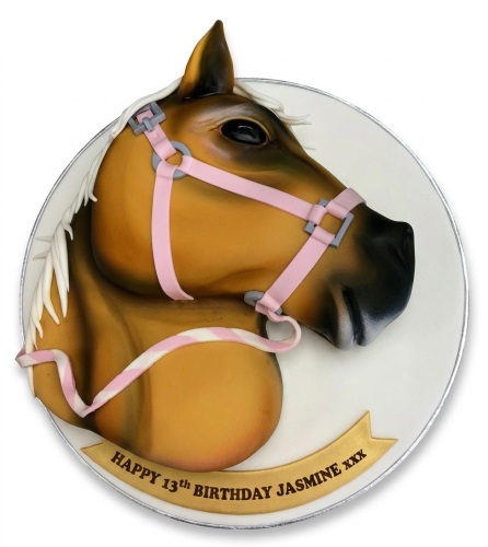3D horse head birthday cake with brown coat, white mane, and pink bridle on a white board with a custom message banner.