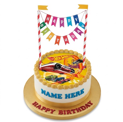 Round white cake with a yellow top featuring Hot Wheels cars and a 'Happy Birthday' banner topper.