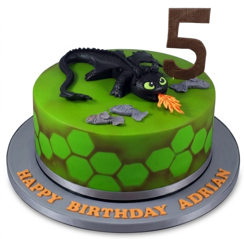 Green birthday cake with black Toothless dragon, fish decorations, and a custom age topper.