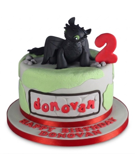 Round How To Train Your Dragon cake with Toothless figurine and custom age topper.