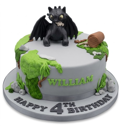 Grey birthday cake with 3D Toothless dragon figure, green foliage, and custom age/name.