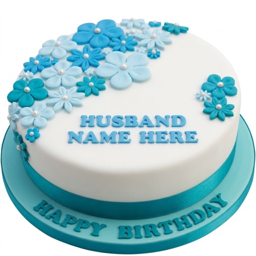 Round white birthday cake with blue fondant flowers and a custom message for husband.