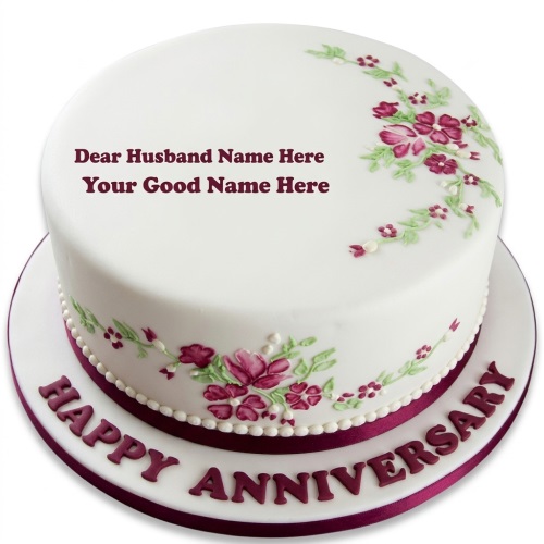 White round anniversary cake with maroon and green floral design, pearl border, and "Happy Anniversary" on the board.
