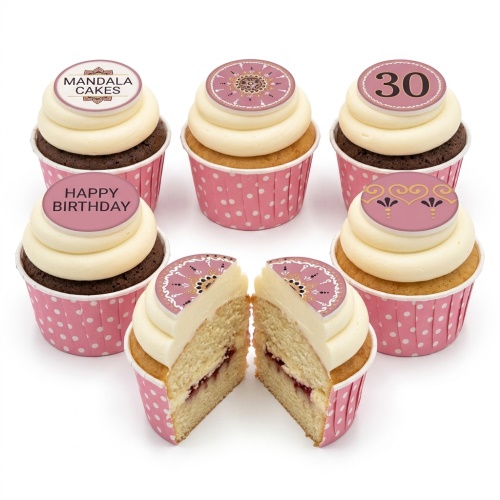 Six cupcakes with cream frosting, pink polka dot wrappers, and round mandala-patterned toppers. One topper says "Happy Birthday", another shows "30".