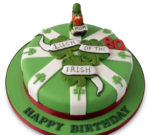 Green Irish theme birthday cake with leprechaun, shamrocks, and custom age topper.
