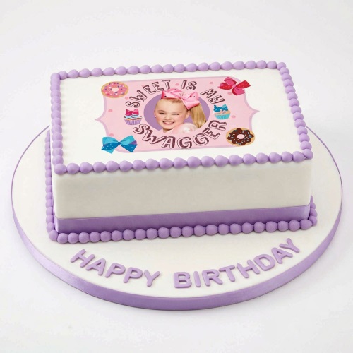Rectangular JoJo Siwa themed birthday cake with white icing, purple borders, and 'Happy Birthday' text.