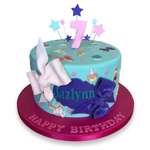 Teal unicorn birthday cake with pink and purple bows, stars, and custom age topper.