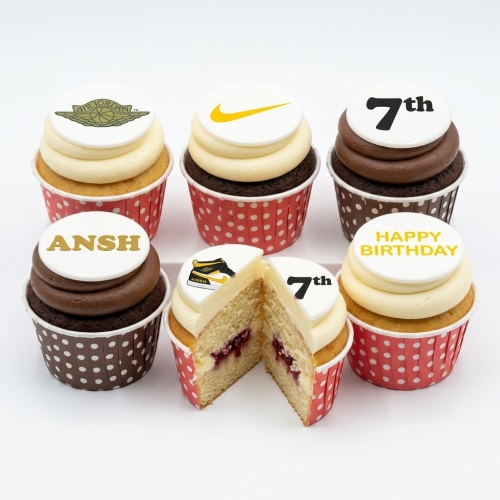 Assortment of vanilla and chocolate cupcakes with sneaker brand logos and custom birthday toppers.