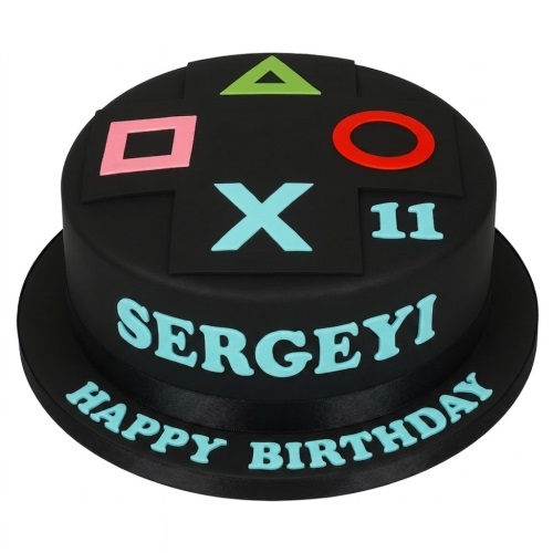 Black round PlayStation gaming cake with controller symbols, custom name, and age