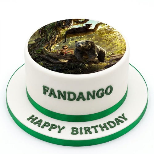 Round white cake with green ribbon, featuring an edible image of Mowgli, Baloo, and Bagheera from The Jungle Book, with custom name and 'Happy Birthday' message.