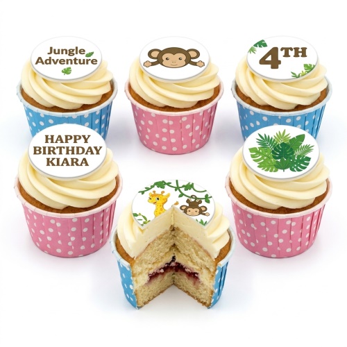 Six jungle-themed cupcakes with animal and leaf toppers, some in pink and blue polka dot wrappers.