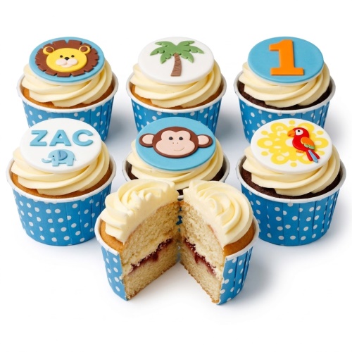 Vanilla cupcakes with blue and white polka dot wrappers, topped with white frosting and jungle animal fondant decorations.